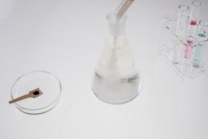 A beaker, test tubes, and petri dish on a white surface; harmless-looking things that can be dangerous.
