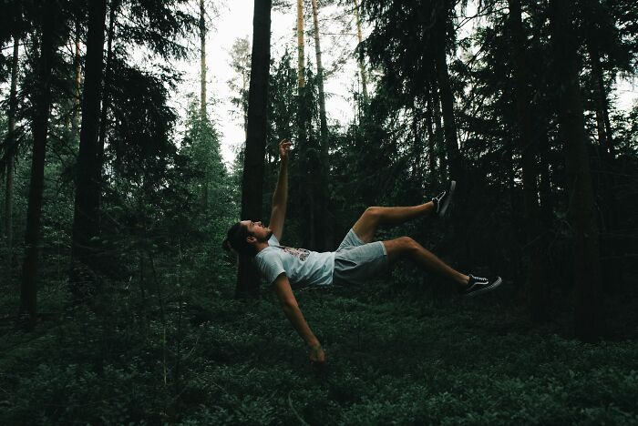 A man floating horizontally in a dark forest, illustrating harmless-looking things that can be way more dangerous.