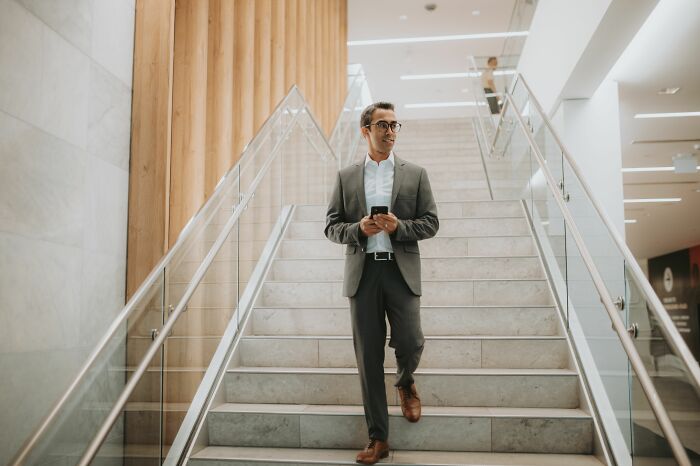A man in a suit walking down stairs, looking around. Harmless-looking things can be dangerous.