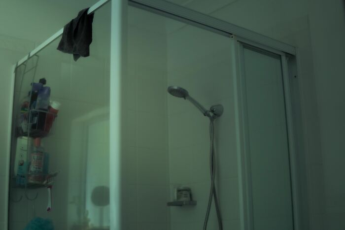 A shower with a glass enclosure and showerhead; a harmless-looking thing that can be dangerous.
