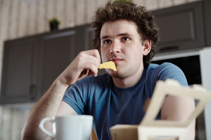 A young man eating a single chip, seemingly harmless, yet things can be more dangerous than realized.