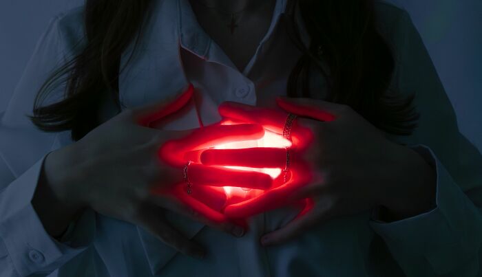 Hands cupped together with a glowing red light emanating from within. Harmless-looking things can be more dangerous.