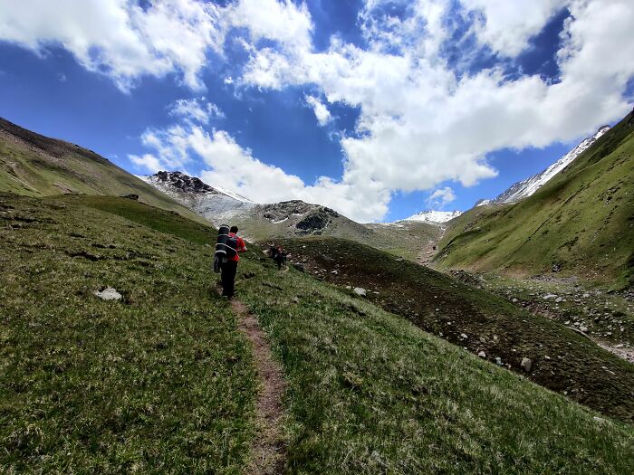 Hikers on a trail in the mountains, symbolizing interesting encounters with American tourists.