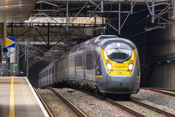A high-speed train arrives at a station, a typical mode of transport for American tourists on their travels.