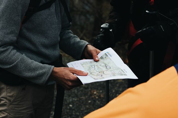 A person holding a map, a typical scene for American tourists navigating an unfamiliar place.