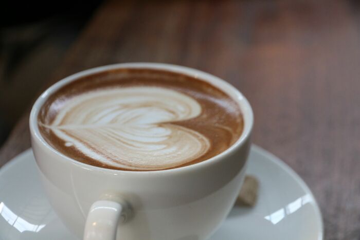 A close-up of a cup of coffee with latte art, representing funny encounters with American tourists.