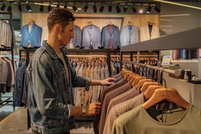 A man shops for clothes, representing a common activity for American tourists.