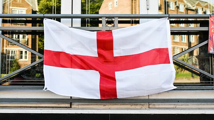 An English flag hanging from a railing, a symbol American tourists might encounter.
