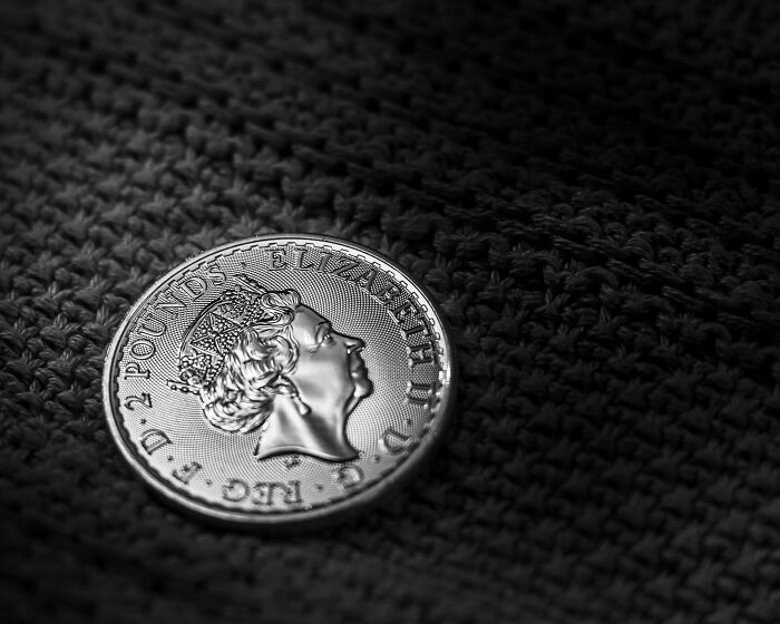A close-up of a British coin featuring Queen Elizabeth II, a common item encountered by American tourists.