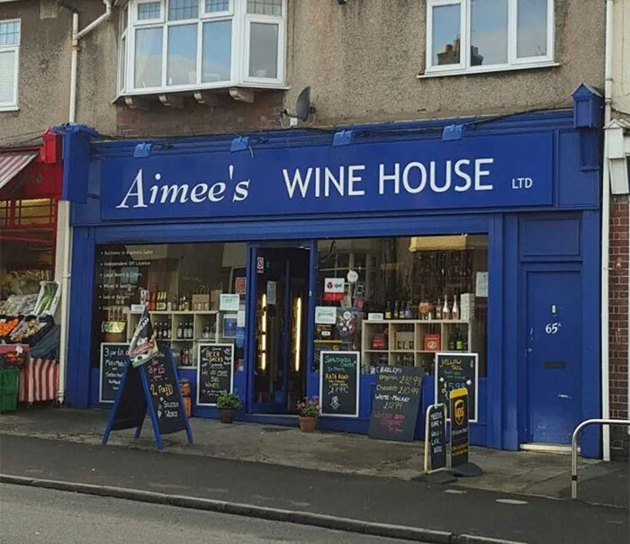 Aimee's Wine House with a dry British humor sign in front of the shop.