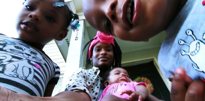 A family of a mom and three children in a group photo, illustrating the joyful and fulfilling aspects of motherhood.