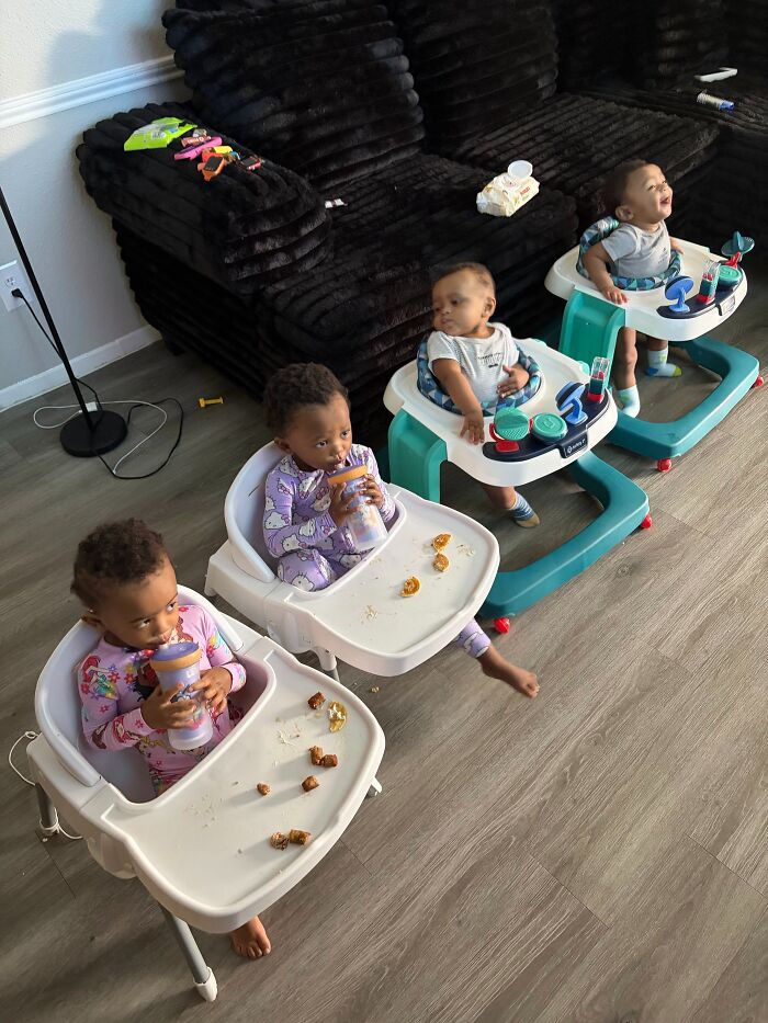 Four babies in high chairs and walkers, showcasing the rewarding and joyful, but challenging, journey of motherhood.