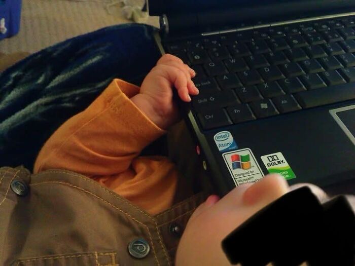 A baby's hand reaching for a laptop keyboard, representing the rewarding yet not easy journey of motherhood.
