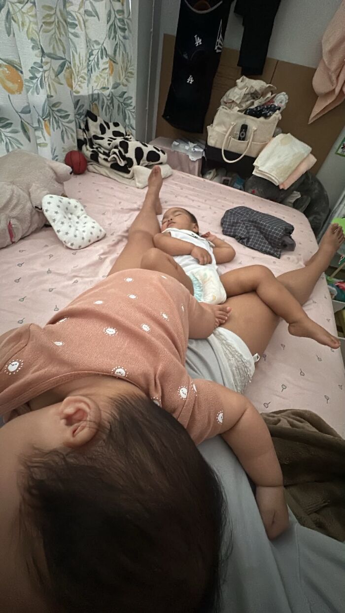 A mom sleeping with her two babies on a bed, showcasing the fulfilling yet not always easy journey of motherhood.