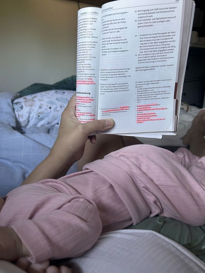 A pregnant woman lying in bed, reading a book, representing the journey of motherhood.