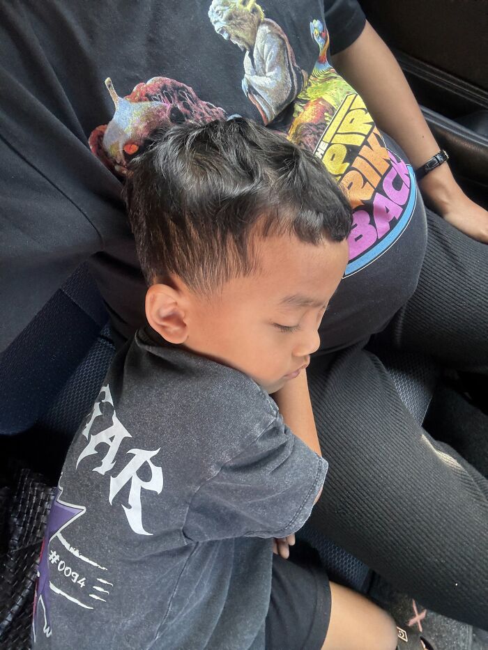 Motherhood is rewarding: A sleeping child rests comfortably against a parent, illustrating a peaceful, fulfilling moment.