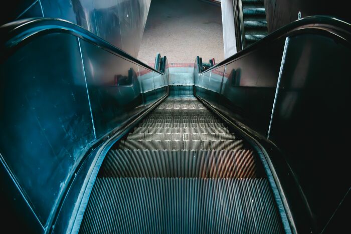 Looking down a long escalator, an everyday scene that can sometimes be absurd and hilarious.