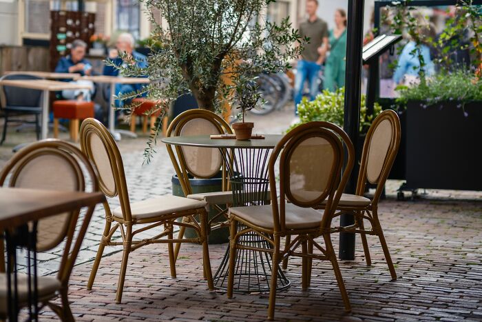 A quaint outdoor cafe with empty tables on a brick patio, highlighting absurd and hilarious things people witness.