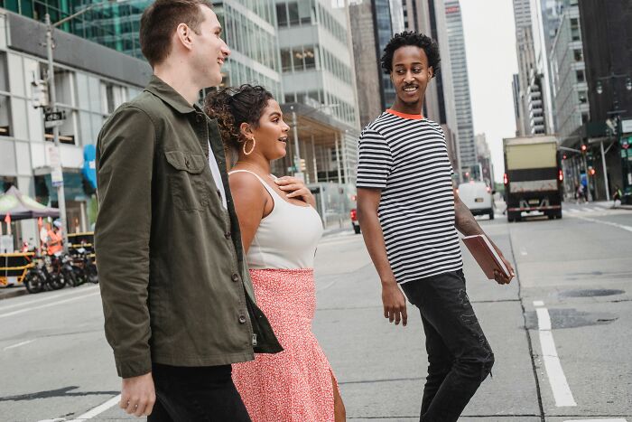 Three friends crossing a city street, a hilarious and absurd moment of urban life.