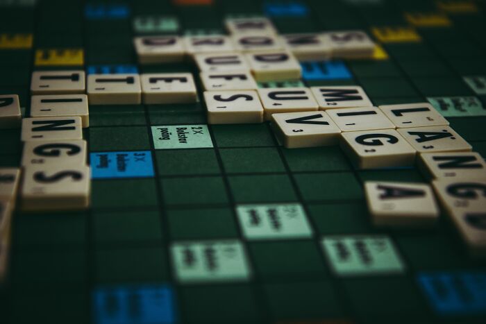 A Scrabble board displaying various word tiles, an absurd and hilarious sight for word game enthusiasts.
