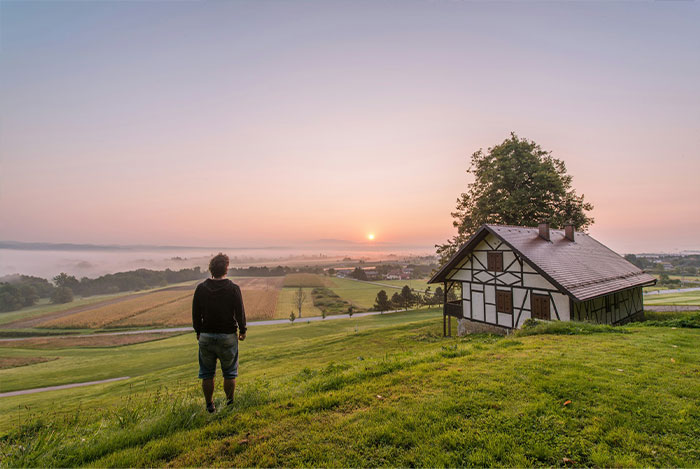 A resident overlooks their property with an old house, contemplating an HOA secret scheme.