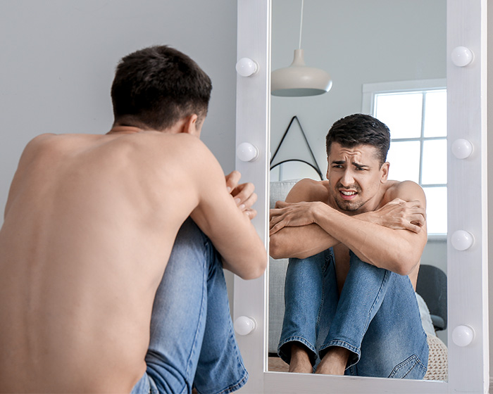 A man looking distressed in a mirror, reflecting on Hollywood Star's raw confession about extreme food habits. A man looking distressed in a mirror, reflecting on Hollywood Star's raw confession about extreme food habits.