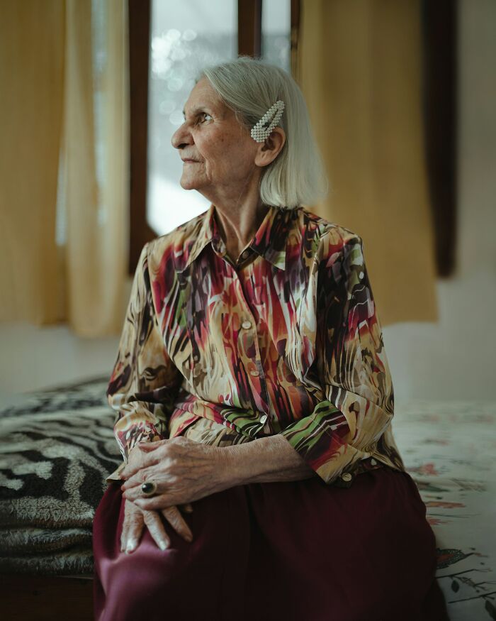 An older woman with a pensive expression, possibly reflecting on creepy true stories that question reality.