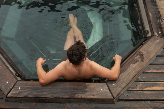 An overhead view of a man relaxing in a hot tub, purchased after pool access was denied. An overhead view of a man relaxing in a hot tub, purchased after pool access was denied.