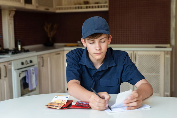 A young man in a blue cap, calculating expenses, planning to buy a hot tub after pool access denied. A young man in a blue cap, calculating expenses, planning to buy a hot tub after pool access denied.