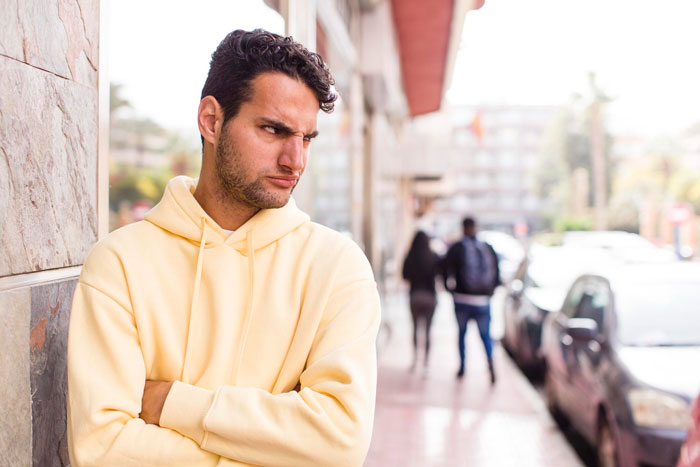 A man with a disgruntled expression, arms crossed, reflecting how a husband left pregnant woman in relationship. A man with a disgruntled expression, arms crossed, reflecting how a husband left pregnant woman in relationship.
