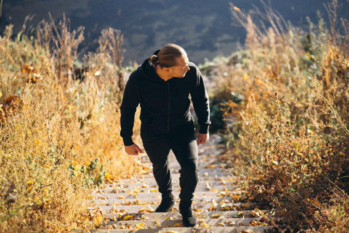 A husband walks up a leaf-strewn outdoor staircase, reflecting the challenges of a pregnant relationship. A husband walks up a leaf-strewn outdoor staircase, reflecting the challenges of a pregnant relationship.