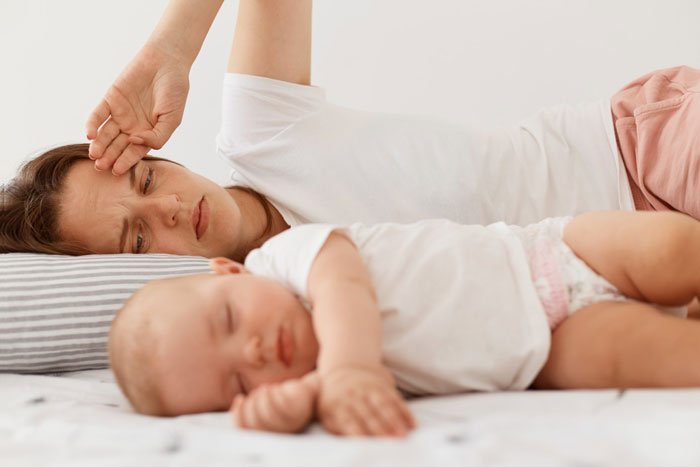 A tired mother lying in bed next to her sleeping baby, after discovering her husband wants their daughter named after his best friend. A tired mother lying in bed next to her sleeping baby, after discovering her husband wants their daughter named after his best friend.