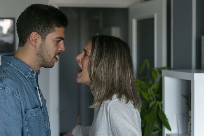 A couple is screaming at each other in an intense moment during an argument in their home.