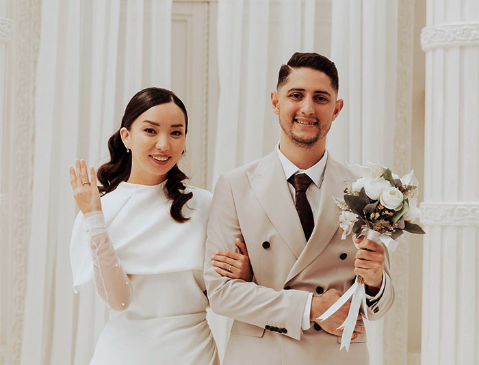 Smiling husband and wife on their wedding day, a husband holding a bouquet. A woman waits 25 years to apologize. Smiling husband and wife on their wedding day, a husband holding a bouquet. A woman waits 25 years to apologize.