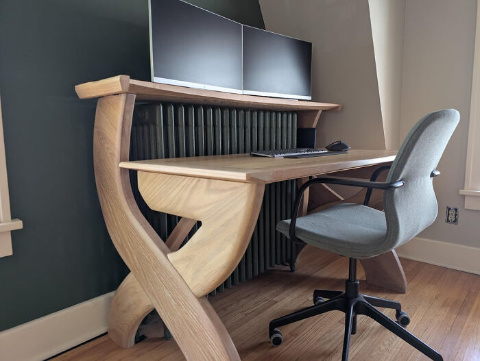 A DIY home project featuring a unique wooden desk with two monitors and a gray office chair, transforming a space.