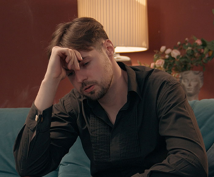 Man looking stressed, representing awkward times people shared too much when nobody asked them to. Man looking stressed, representing awkward times people shared too much when nobody asked them to.