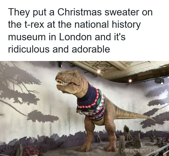 A T-Rex dinosaur model at a museum wearing a funny Christmas sweater, making it a funny science meme.