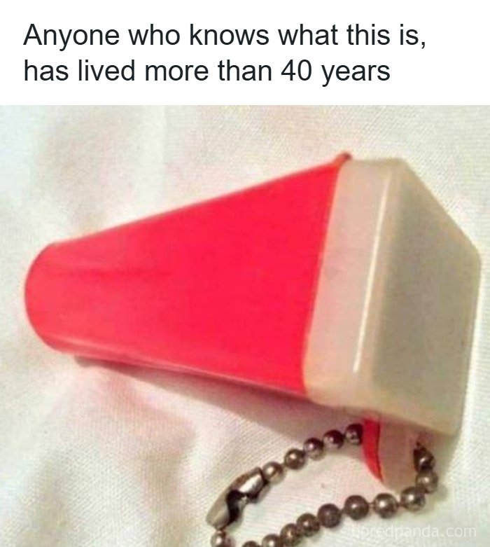 A small, red plastic whistle with a metal chain, a nostalgic item from the 80s.