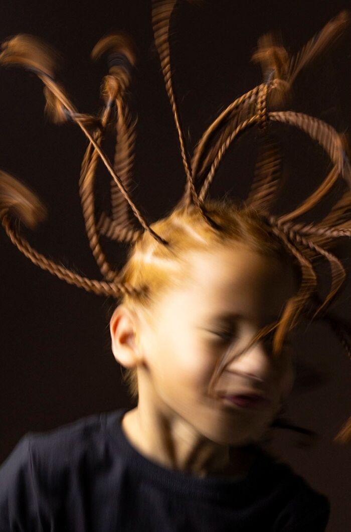 A blurry image of a young natural redhead child with braided hair, celebrating natural redheads.