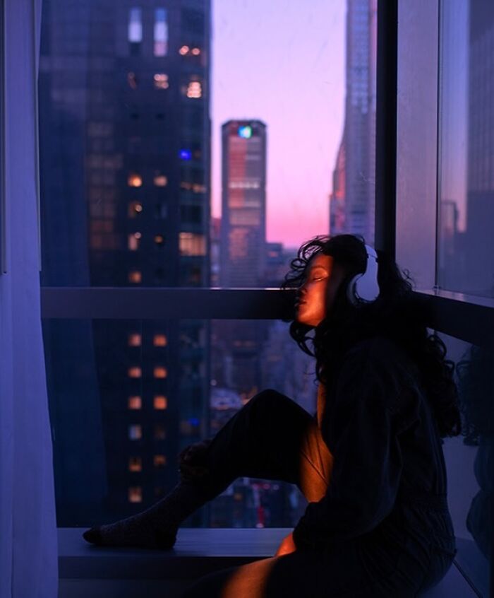 Oliver Takáč captures cinematic portraits with neon lights, showing a woman with headphones overlooking a city.