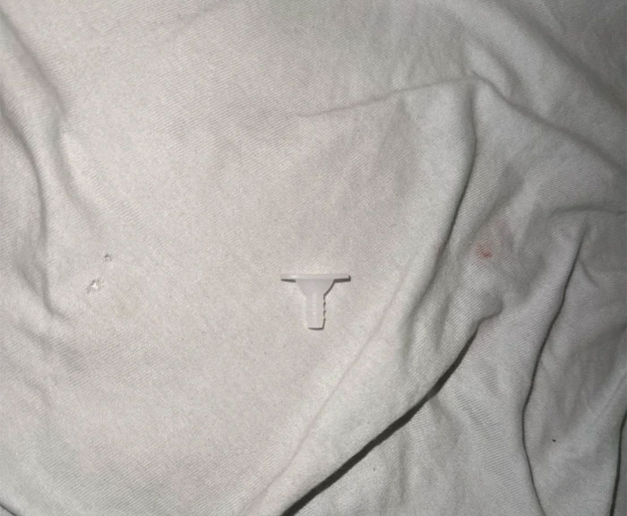 A small, white, weird object, possibly a plastic vape filter, found in a son's room.