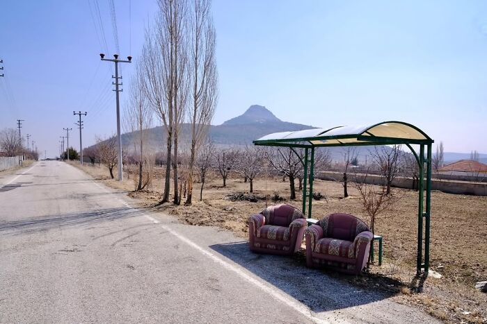 A candid moment from the streets: two armchairs under a bus stop shelter in a rural setting, by Sami Uçan.