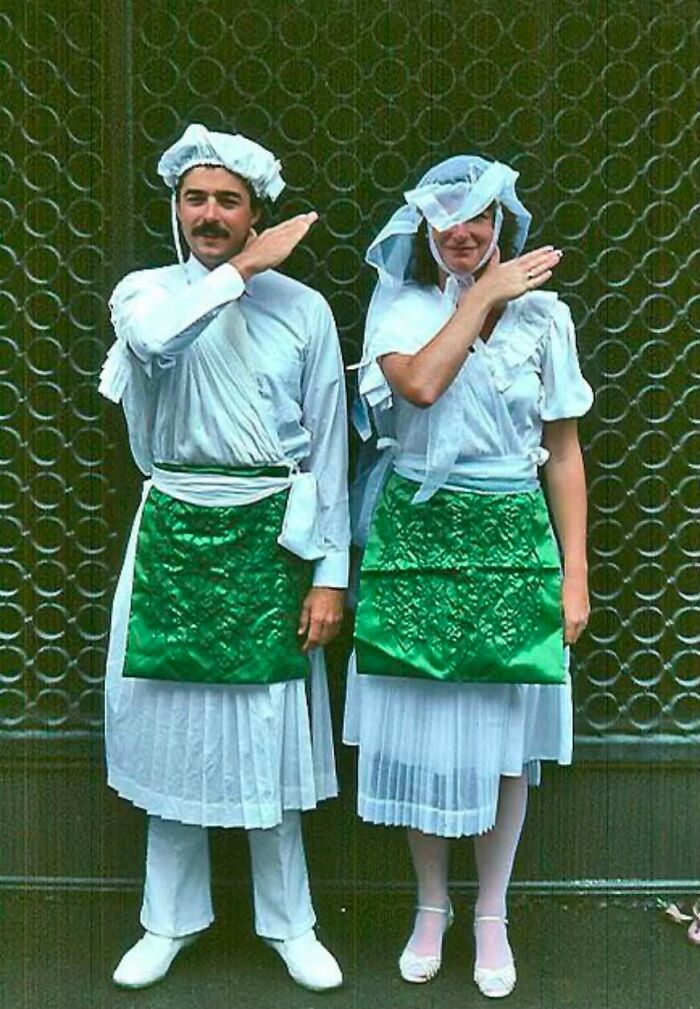 A man and a woman in matching white and green outfits, making a gesture with their hands. This image relates to cults and ADHD.
