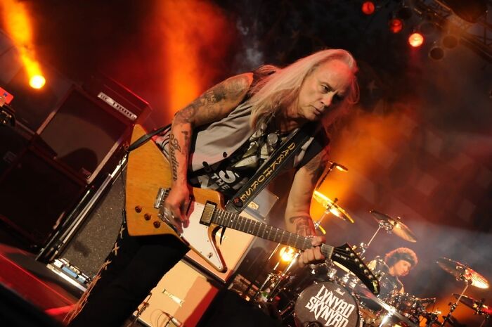 Gary Rossington of Lynyrd Skynyrd performing on stage, showcasing the reality of dating a celebrity.