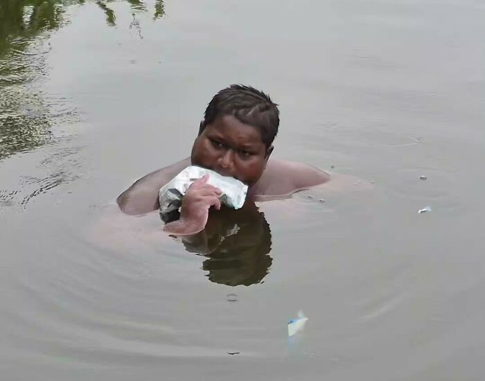 Teen with mysterious condition in a pond, consuming something from a bag to alleviate his symptoms.