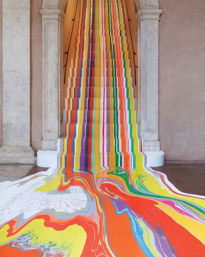 Beautiful designs: A grand staircase covered in a cascade of colorful, melting paint, creating a brilliant design.