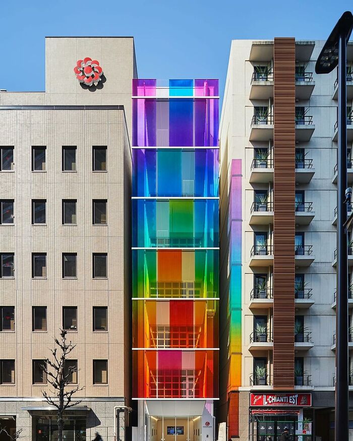 Beautiful designs: A vibrant rainbow-colored building facade between two muted gray buildings.
