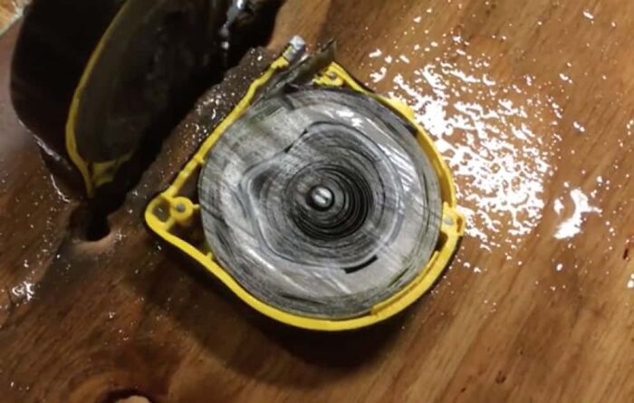 Surprising photo of a tape measure cut in half, showing the rolled metal tape and internal mechanism.