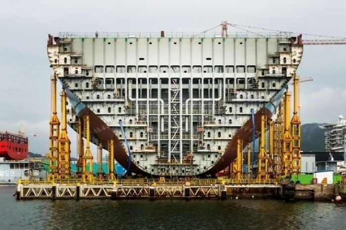 An interesting photo of an object cut in half: a massive ship hull section, showing its internal structure during construction.