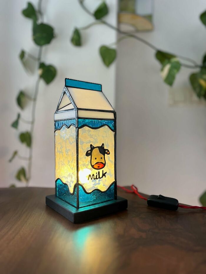 Stained glass milk carton lamp with a cartoon cow, an example of amazing crafts.